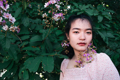 Portrait of woman with pink flower