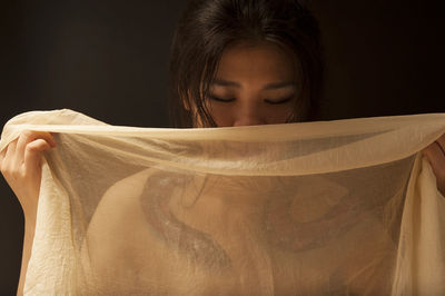 Portrait of a beautiful young woman over black background