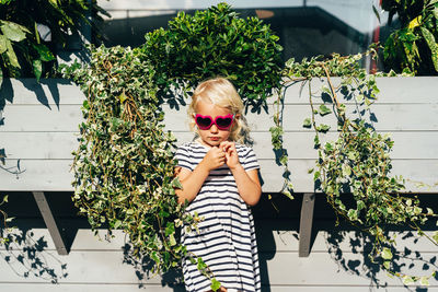 Sad girl in striped dress and sunglasses outside