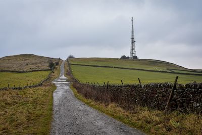 Road amidst field against sky