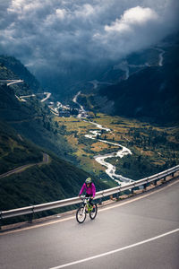 Woman riding bicycle on mountain road