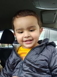 Portrait of smiling boy sitting in car