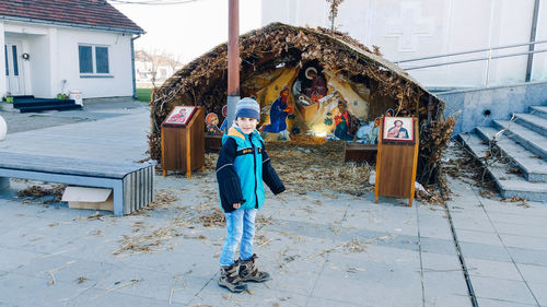 Smiling boy standing on footpath nativity scene