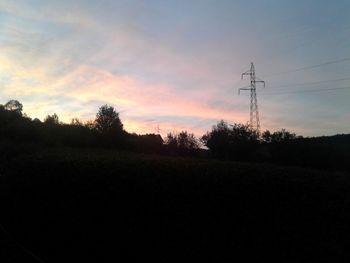 Silhouette trees on field against sky at sunset