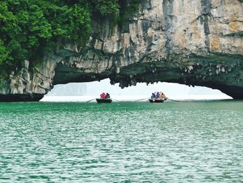 Tourist sailing in boat below mountain