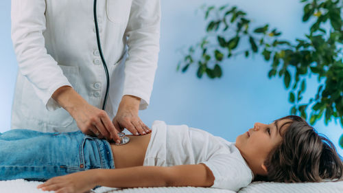 Midsection of doctor examining patient in hospital