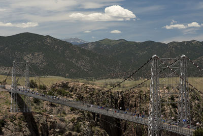 View of suspension bridge against cloudy sky