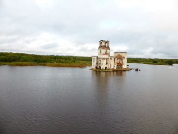 Built structure in lake against sky