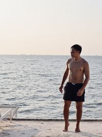 Rear view of man standing at beach