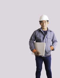 Portrait of smiling man standing against white background