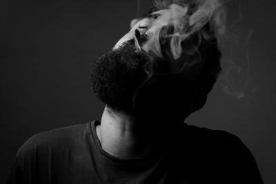 Portrait of young man against black background