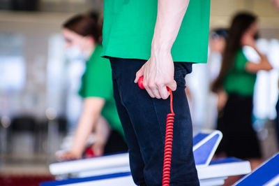 Person standing near swimming pool and keeping time at finish line