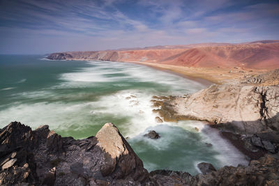 Scenic view of sea and mountains against sky