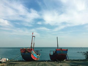 Boats moored on sea against sky