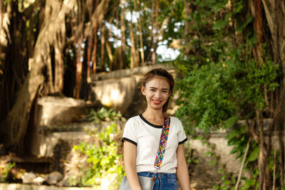 Portrait of smiling young woman in public park