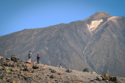 People walking against mountain