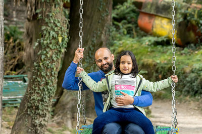 Portrait of boy swinging at playground