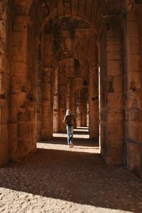 Rear view of woman walking in historic building