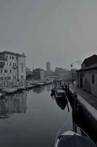 Boats moored in city against clear sky