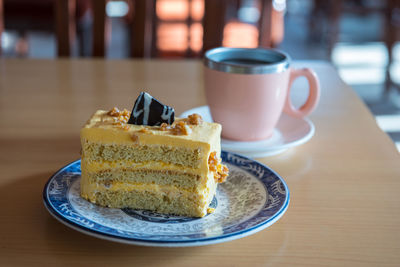 Chocolate peanut butter cake with cup of coffee cup on wooden table