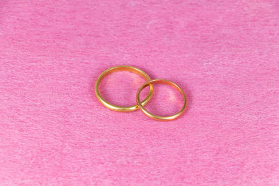 Close-up of wedding rings on pink background