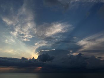 Sunlight streaming through clouds over sea