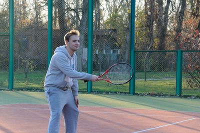 Man playing with ball on fence