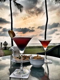 Close-up of drink on table against sky during sunset