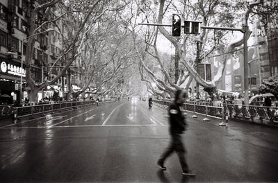 Blurred motion of person walking on road in city