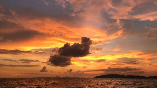 Scenic view of sea against dramatic sky during sunset