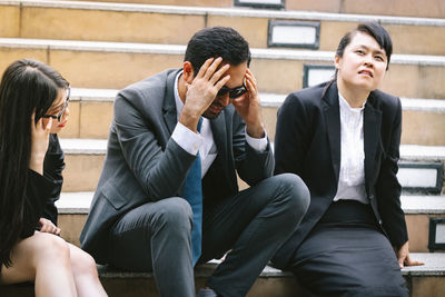 Worried business people sitting on steps