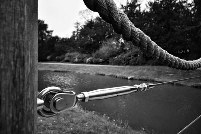 Close-up of chain and trees against sky