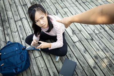 High angle view of woman sitting on wood