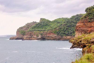 Rock formations in sea against sky