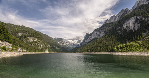 Scenic view of lake by mountains against sky