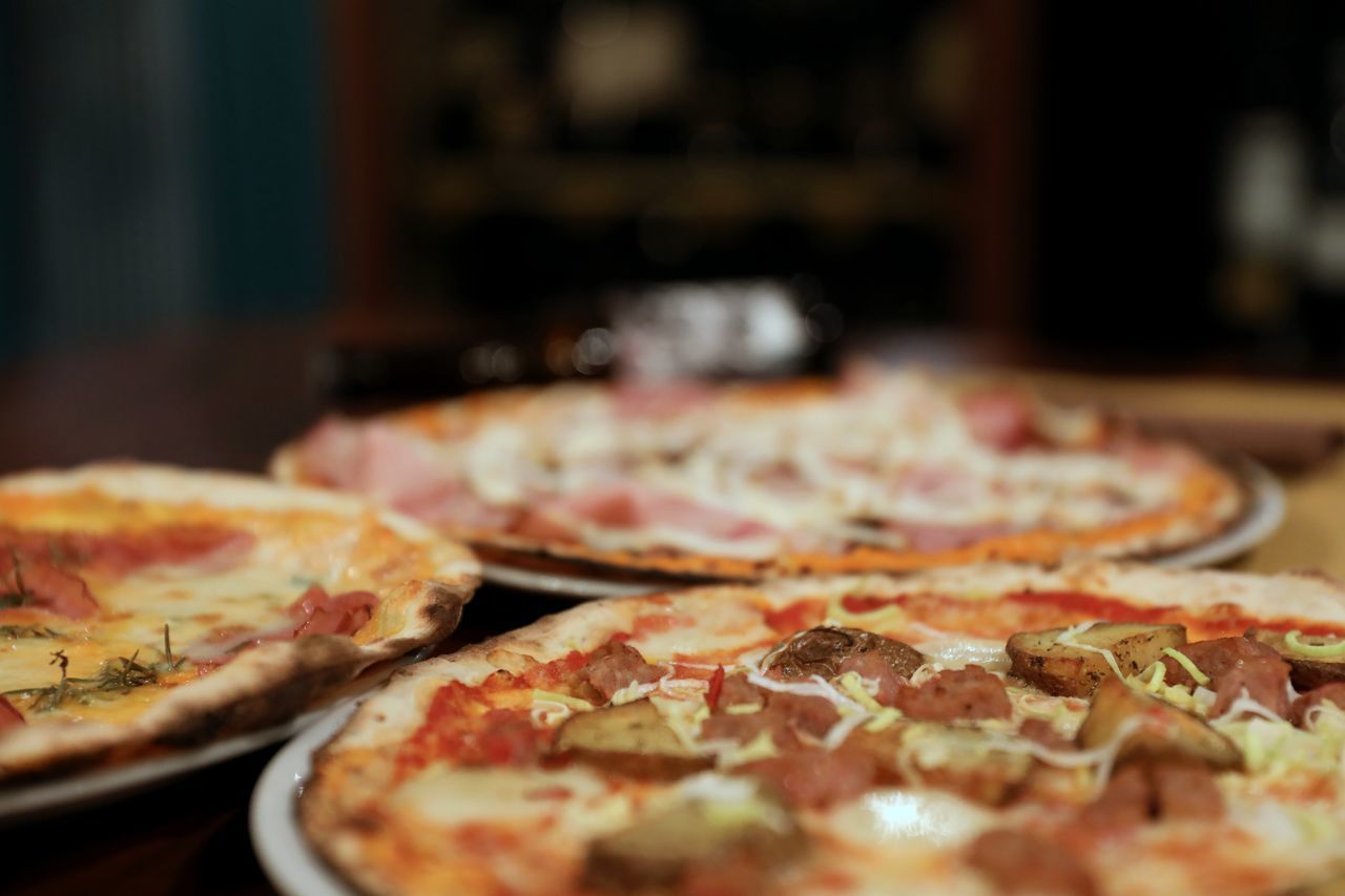 pizza, food and drink, food, dish, italian food, cuisine, freshness, fast food, unhealthy eating, cheese, dairy, restaurant, pepperoni, pizzeria, pepperoni pizza, sausage, fast food restaurant, selective focus, indoors, no people, business, meat, processed meat, close-up, salami, meal, slice, baked, table, vegetable, focus on foreground, mozzarella