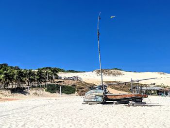 Lifeguard hut on beach against clear blue sky