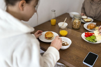 Young lesbian women eating breakfast together at dining table