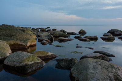 Rocks in sea against sky