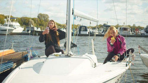 Beautiful woman with girl sitting on boat