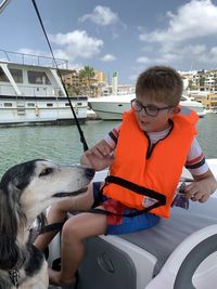 Young boy with saluki dog aboard boat in marbella, spain. 