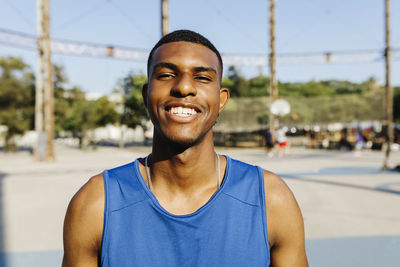 Young man smiling at basketball court
