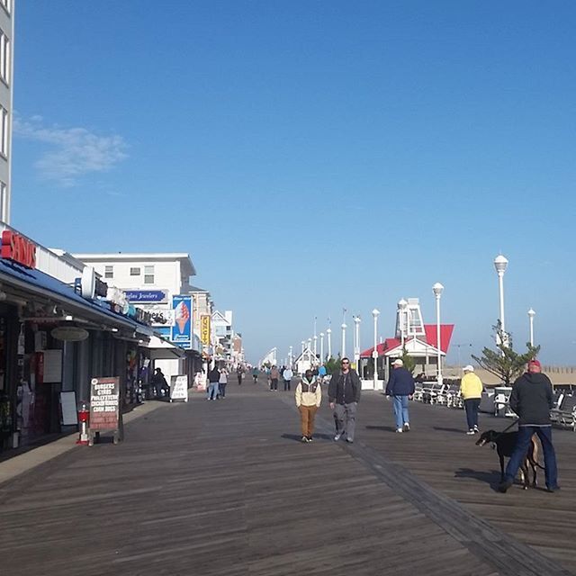 clear sky, blue, copy space, built structure, men, person, architecture, sky, building exterior, lifestyles, the way forward, leisure activity, walking, street light, transportation, day, outdoors, railing, large group of people