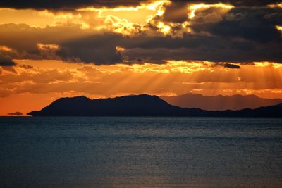 Scenic view of sea against dramatic sky during sunset