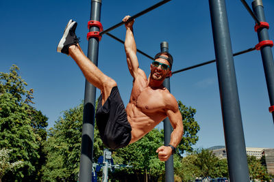 Low angle view of young man exercising at park