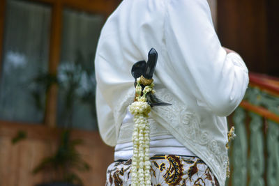 Close-up of man holding white flower