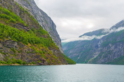 Scenic view of mountains and sea against cloudy sky