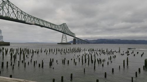 View of bridge over sea against cloudy sky