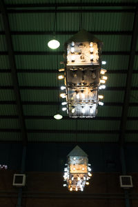 Low angle view of illuminated light bulb hanging on ceiling