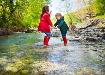 Full length of woman with daughter in water